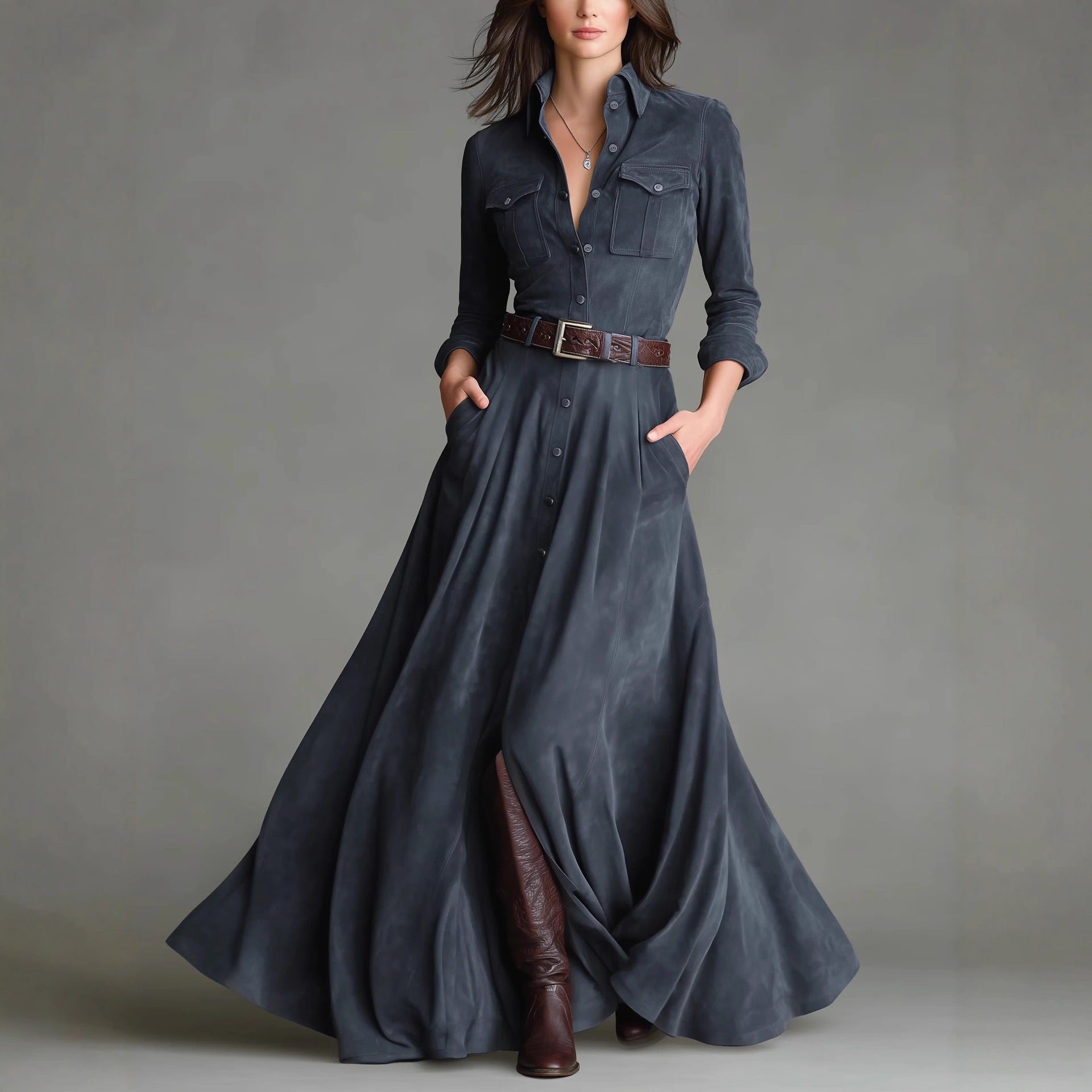 Woman wearing a long denim dress with brown boots against a gray background