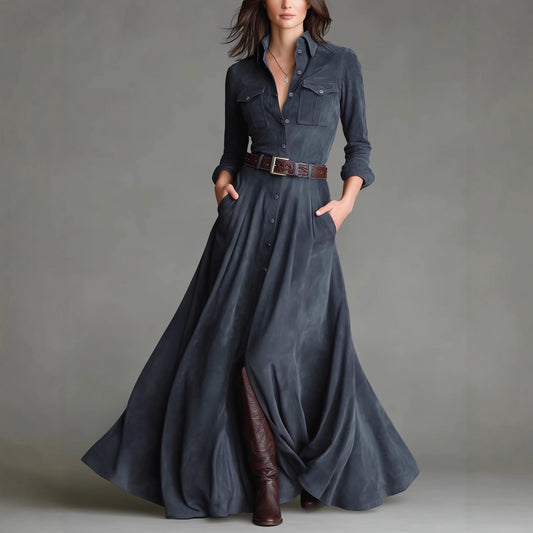 Woman wearing a long denim dress with brown boots against a gray background