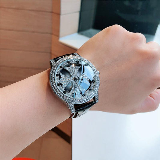 Luxury watch with diamond-studded face on a wrist, blurred background