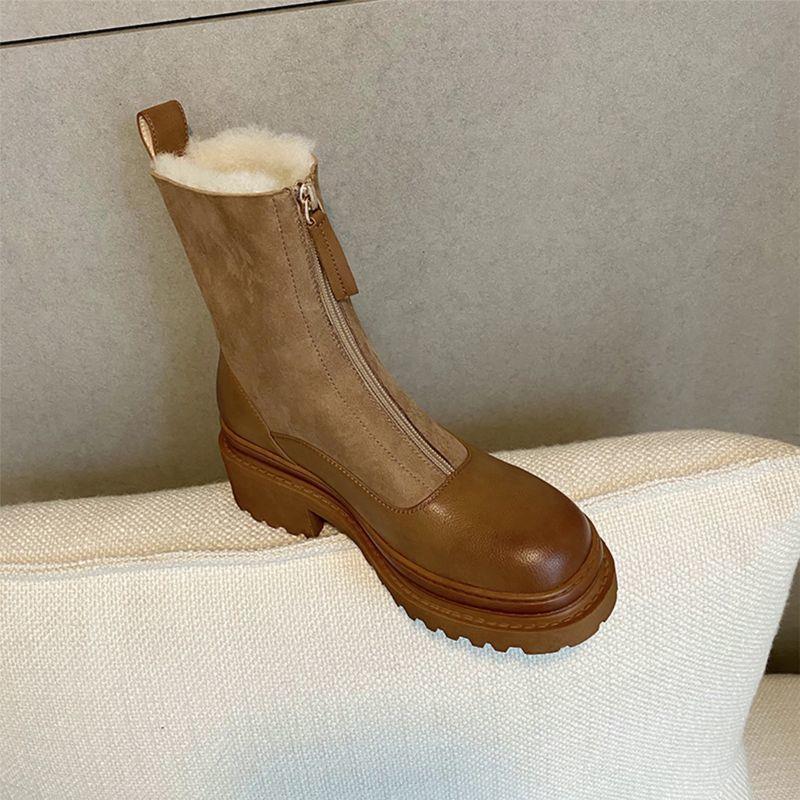 Brown boot with fur lining on a beige surface