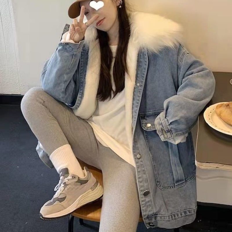 Person wearing a denim jacket with fur lining, sitting on a chair indoors.