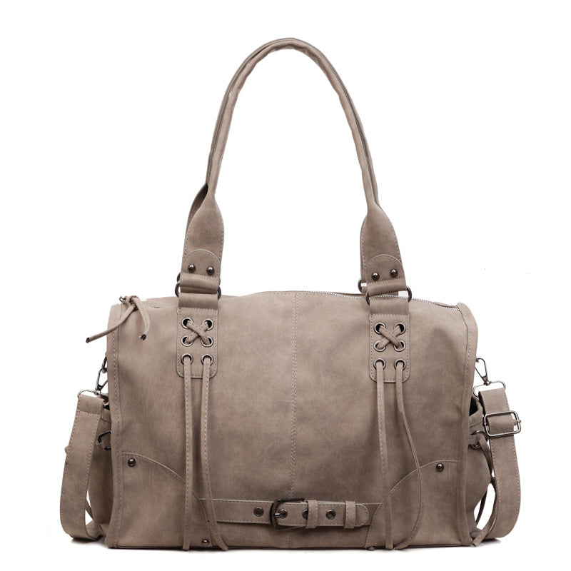 Brown leather bag with multiple straps on a white background