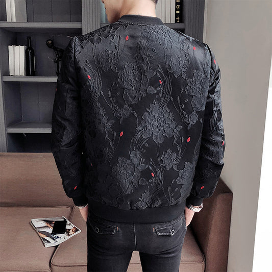 Person wearing a black floral patterned jacket in a room with a couch and books.