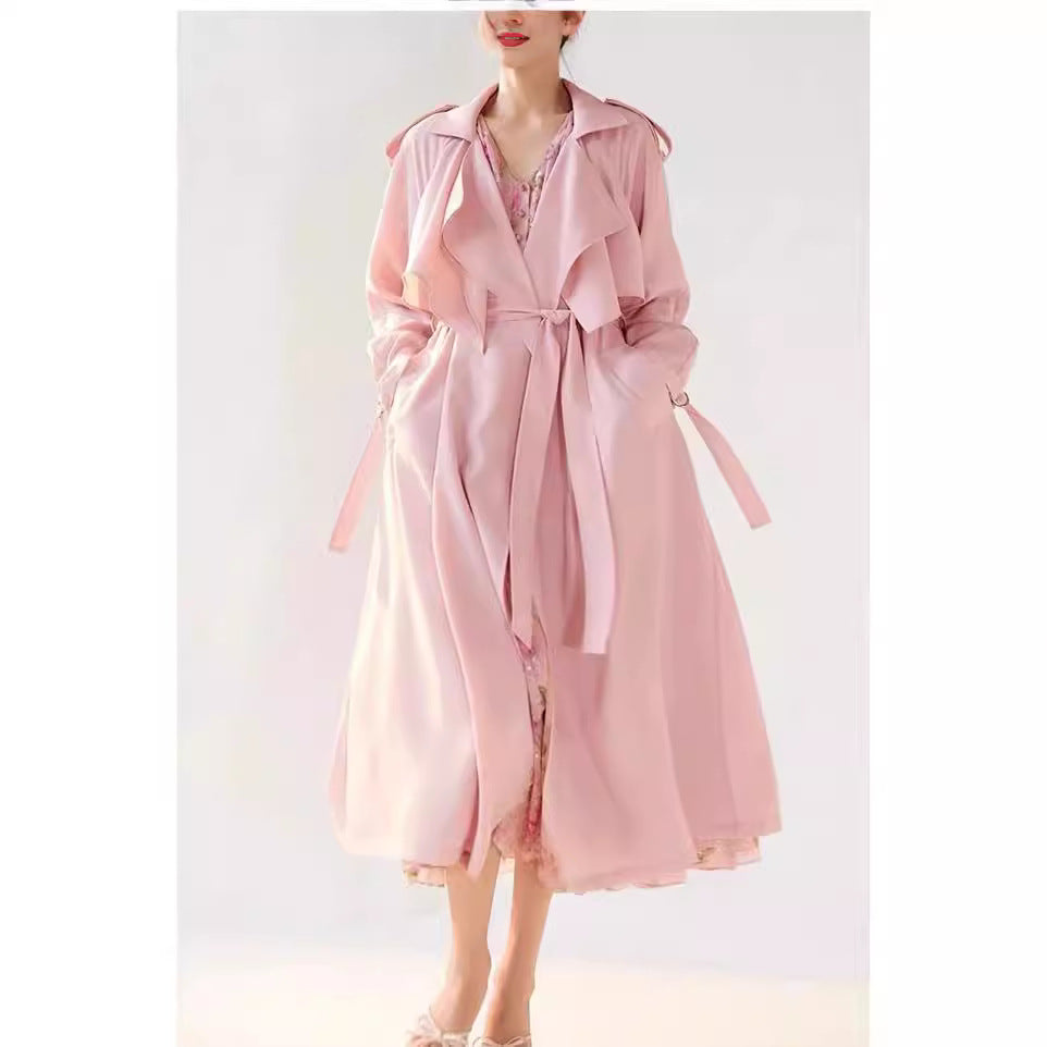 Pink trench coat worn by a person on a white background
