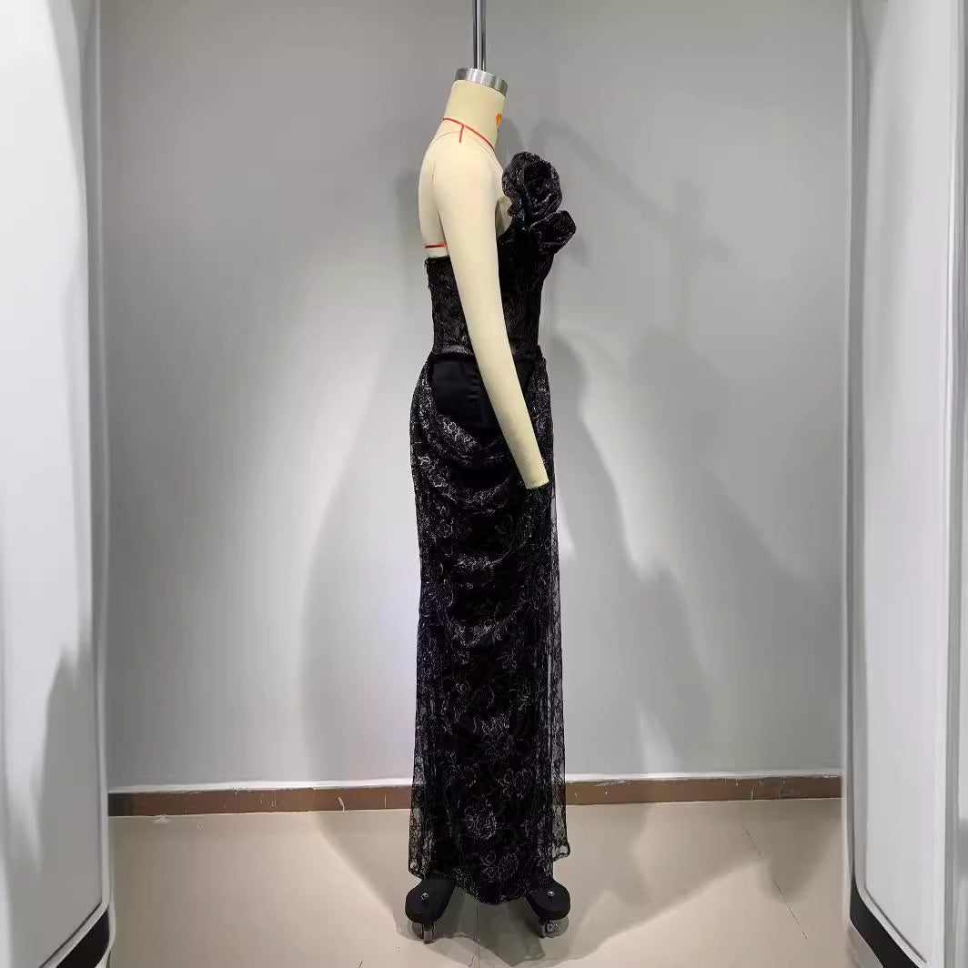 Black evening gown on a mannequin against a plain background