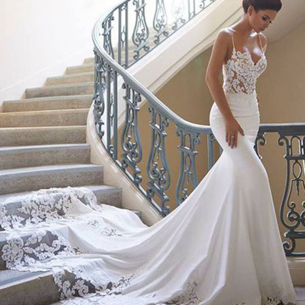 Woman in a white wedding dress standing on a staircase with decorative railings.