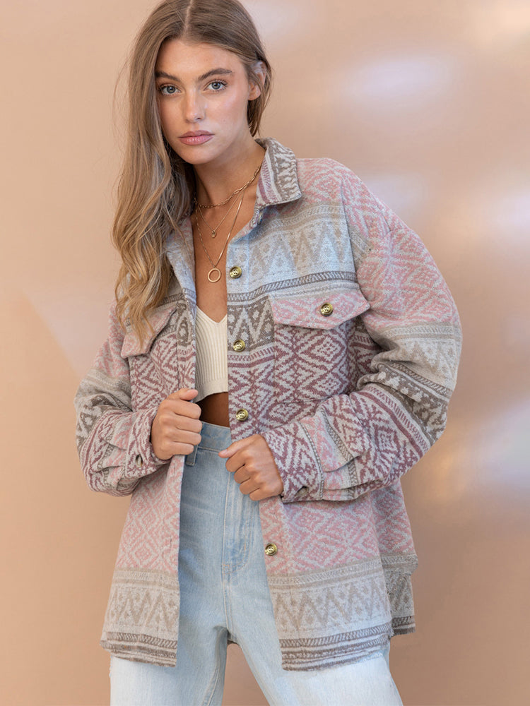 Woman wearing a patterned jacket and jeans against a beige background