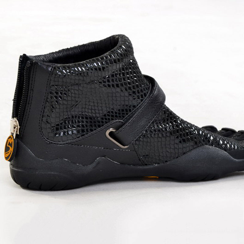 Black high-top sneaker with a strap on a white background