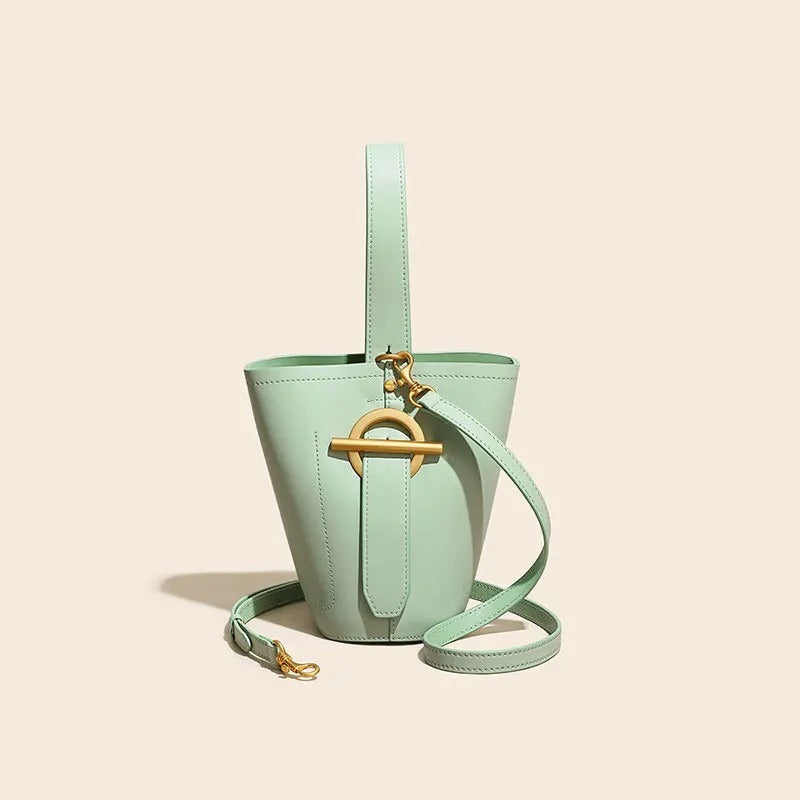 Mint green handbag with a strap on a beige background