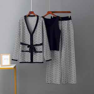 Black and white patterned outfit on hangers against a gray background