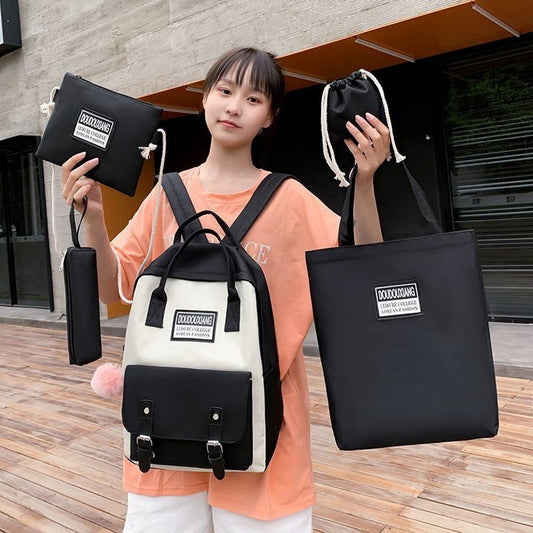 Person holding a black and white backpack and multiple bags with visible branding.