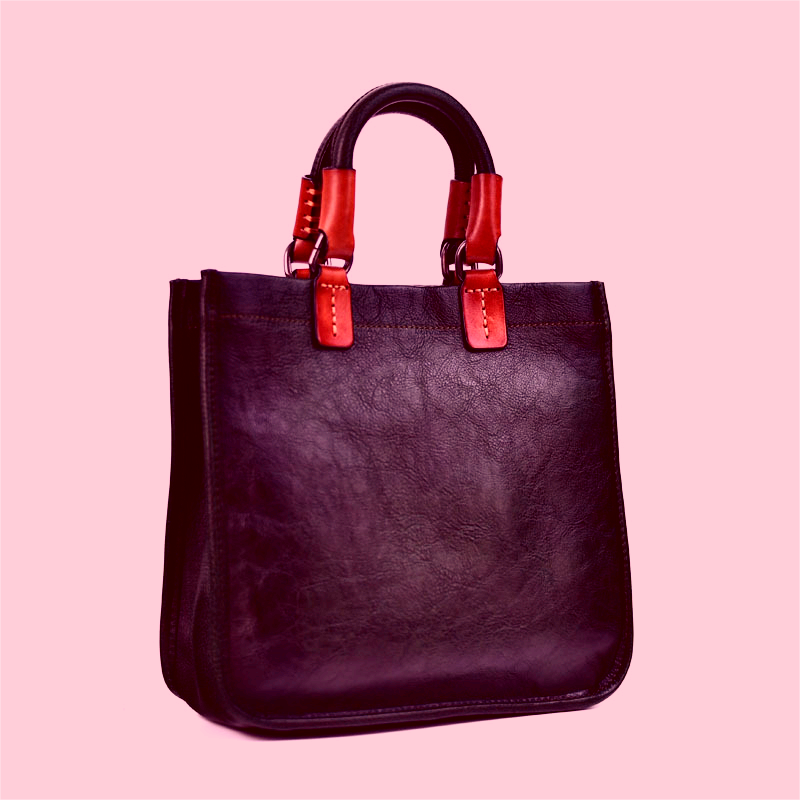 Purple tote bag with red straps on a pink background