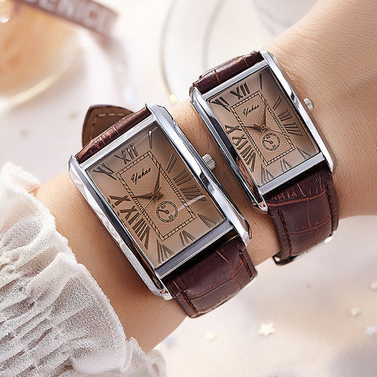 Two rectangular watches with brown leather straps on wrists against a blurred background
