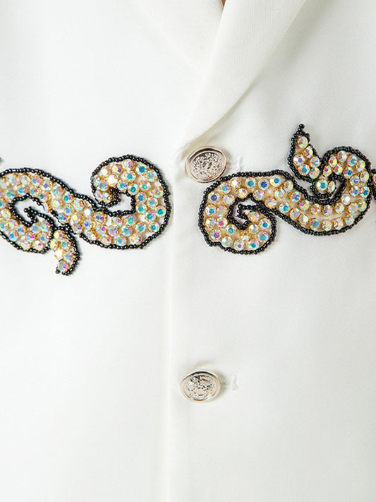 Close-up of a white garment with decorative embellishments on a light background
