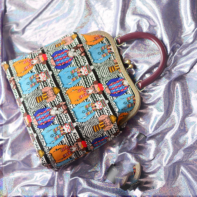 Colorful patterned clutch bag on a reflective silver surface
