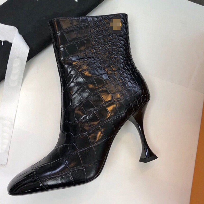 Black crocodile-patterned high-heeled boot on a white background