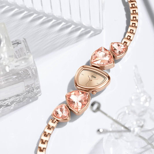 Rose gold watch with pink gemstones on a white surface