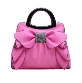 Pink handbag with a large bow on a white background