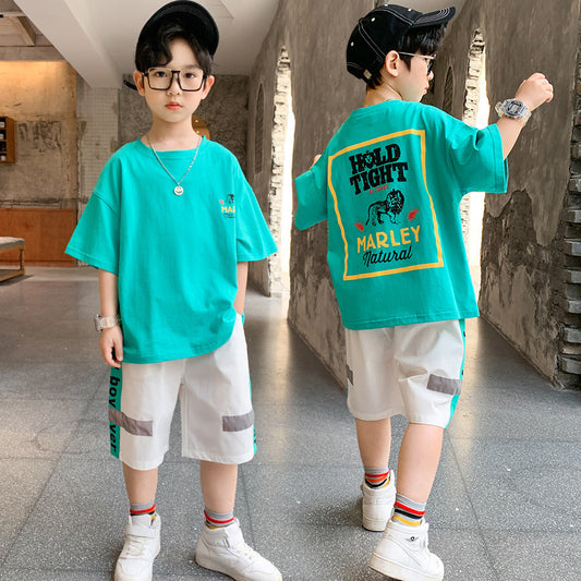 Child wearing a turquoise t-shirt with text and graphics, standing in a hallway.