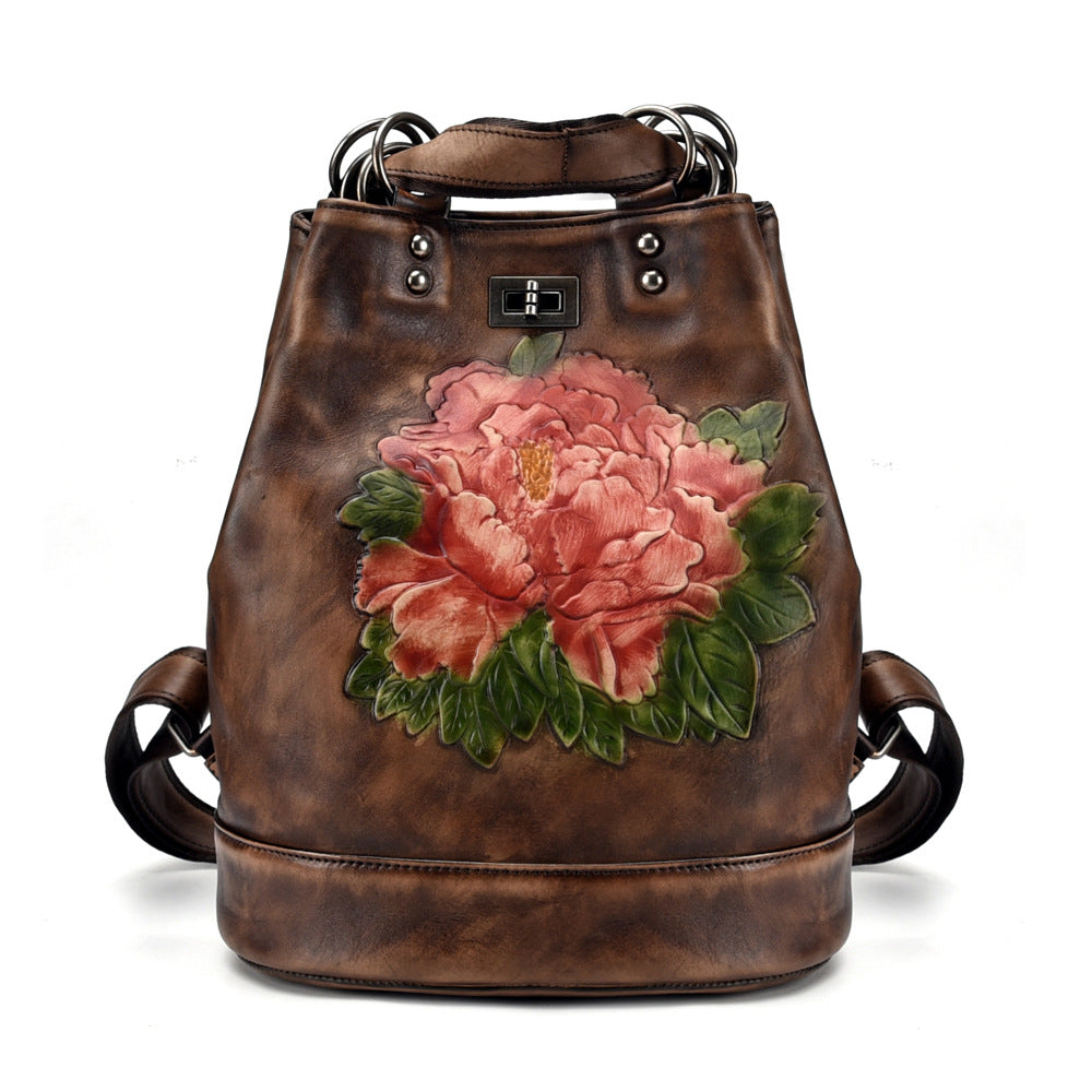 Brown leather backpack with a large pink floral design on a white background