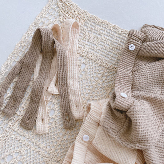 Beige textured fabric with buttons on a light gray background