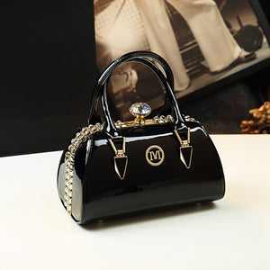Black handbag with gold accents on a white surface