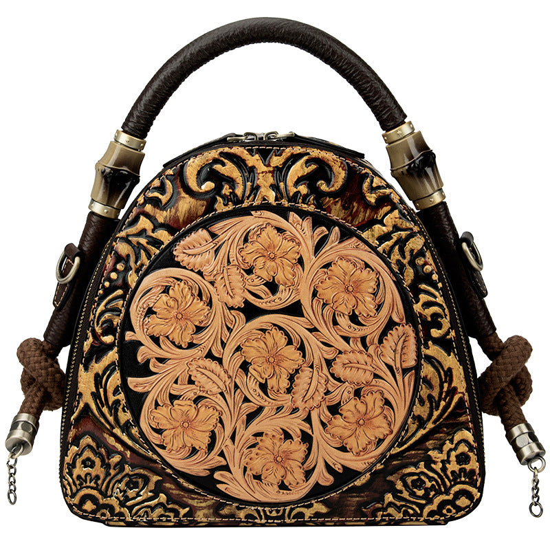 Decorative leather bag with intricate floral patterns on a white background