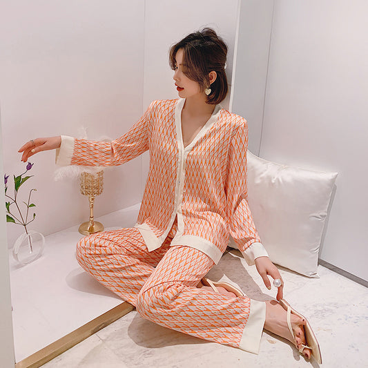 Woman in a peach and white patterned outfit sitting on a white couch.