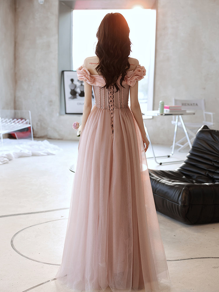 Woman in a long, light pink dress standing in a modern room.