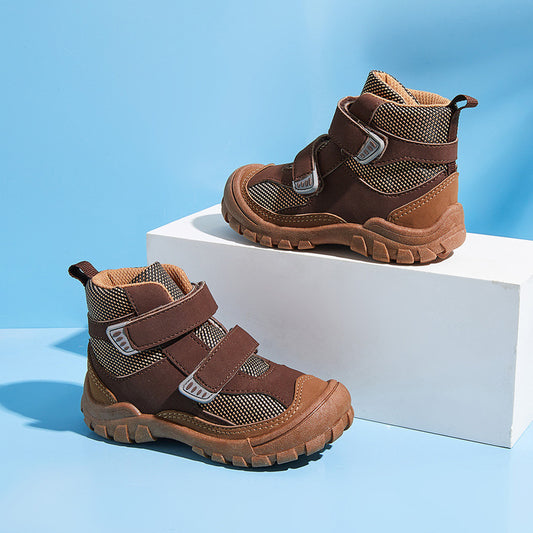 Brown children's boots with velcro straps on a white platform against a blue background