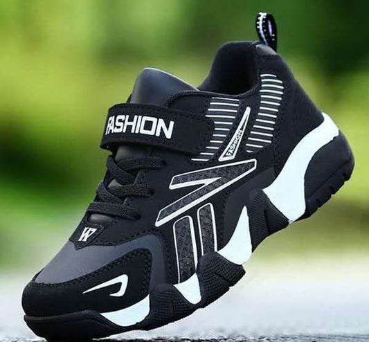 Black and gray sneaker with 'Fashion' label on a blurred green background