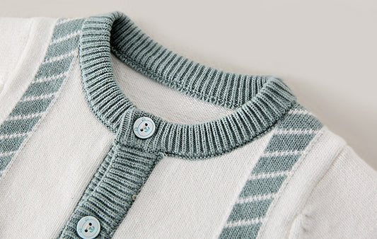 Close-up of a knitted cardigan with a plaid pattern on a neutral background