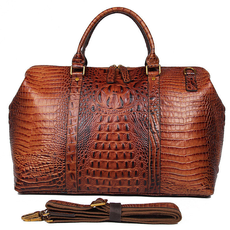 Brown leather handbag with crocodile texture and detachable strap on a white background