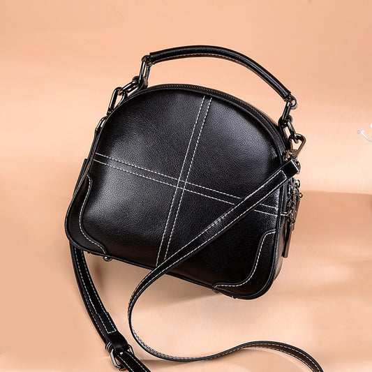 Black handbag with a strap on a beige background