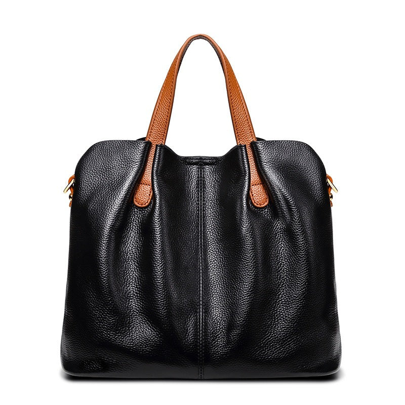 Black leather handbag with brown handles on a white background