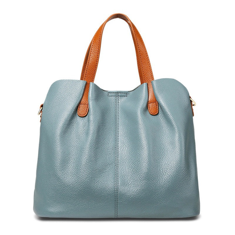 Blue handbag with brown handles on a white background