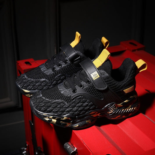 Black sneakers with gold accents on a red surface