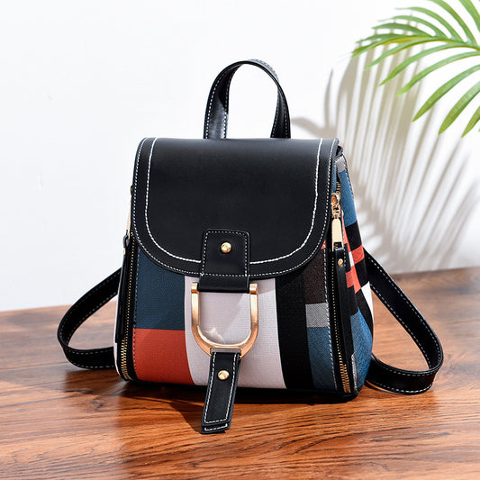 Multicolored backpack with black accents on a wooden surface