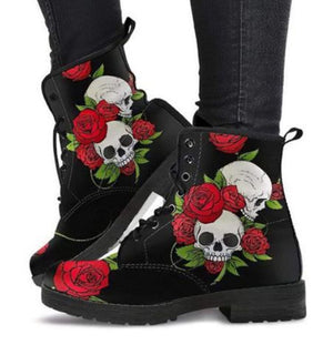Black boots with skull and rose design worn by a person on a white background