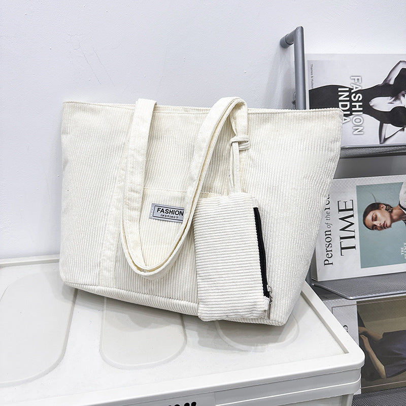 White corduroy tote bag with a smaller matching pouch on a white surface.
