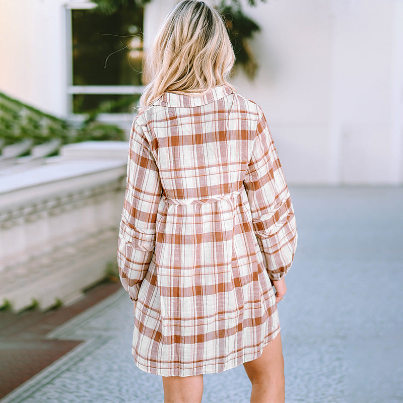 Person wearing a plaid dress standing outdoors.