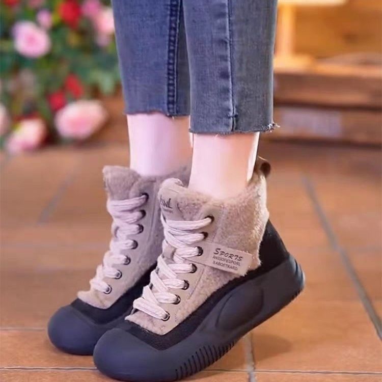 Gray and black winter boots worn with jeans on a tiled floor.