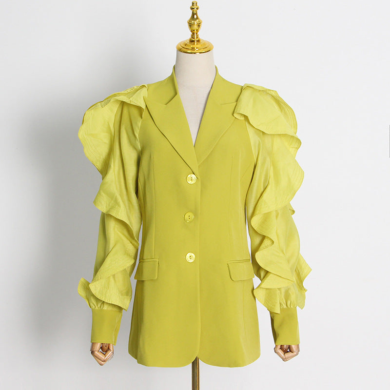 Yellow jacket with ruffled sleeves on a mannequin against a white background