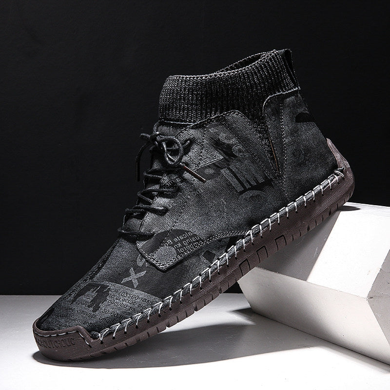 Black high-top sneaker with brown sole on a white surface with black background