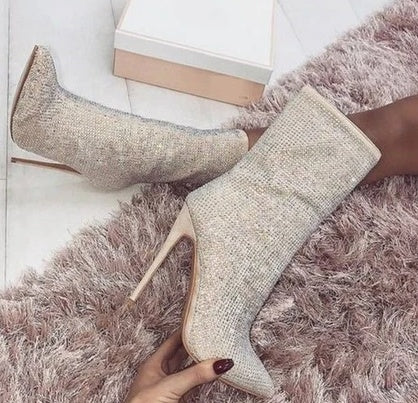 Pair of glittery high-heeled shoes on a fluffy pink rug