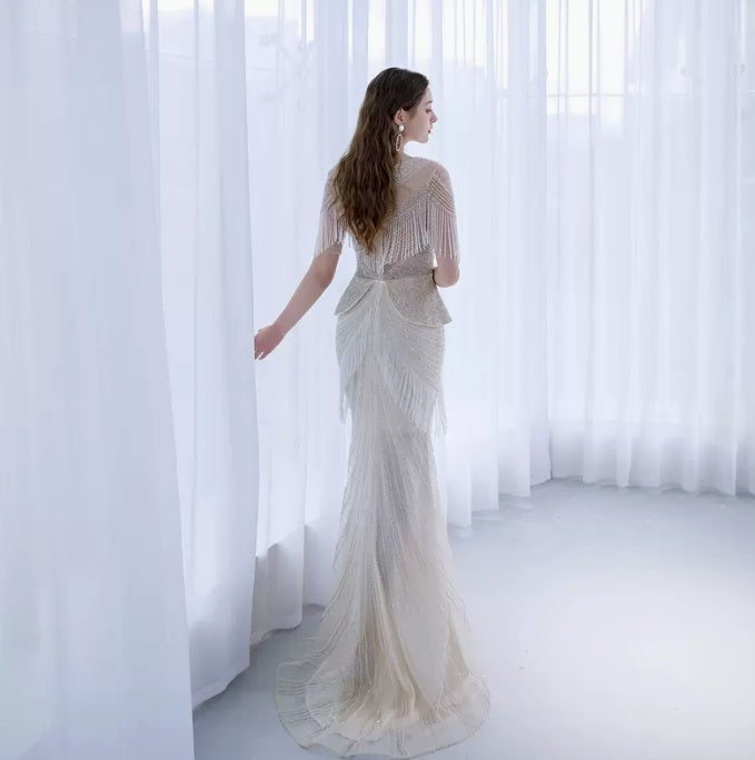 Woman in a white dress standing in front of sheer curtains