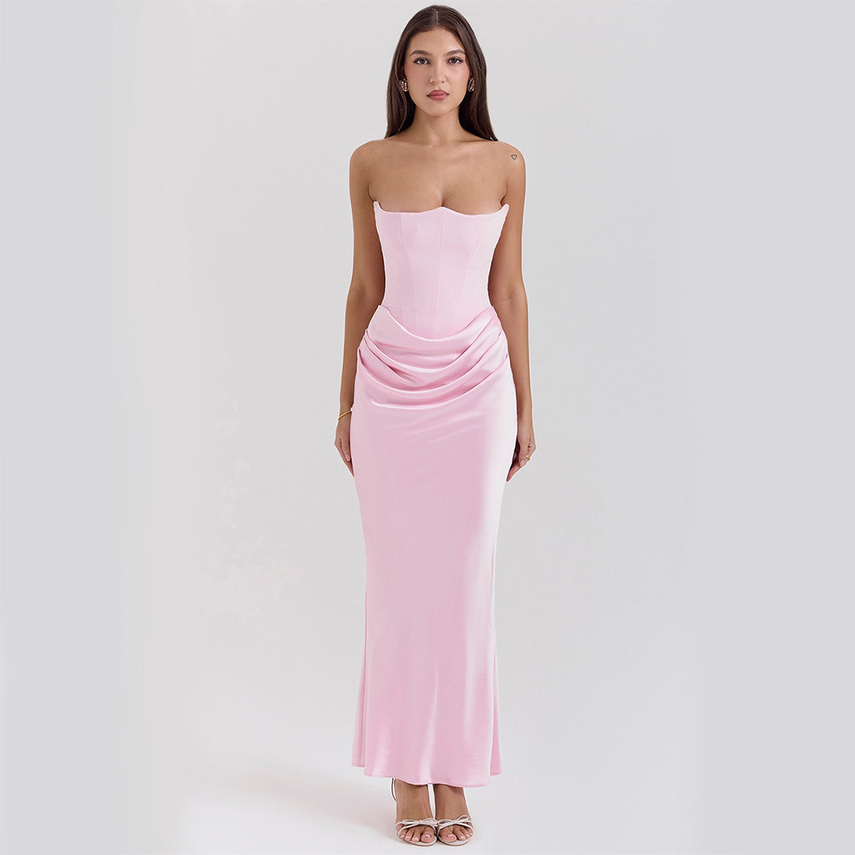 Woman wearing a pink strapless gown on a white background