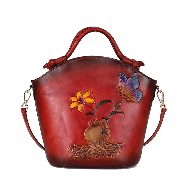 Red handbag with floral and butterfly design on a white background