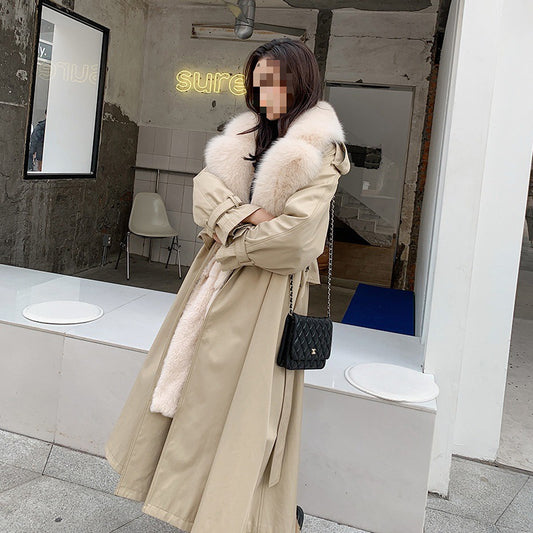 Person wearing a long beige coat with fur trim in an indoor setting. by millivan