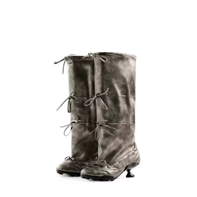Pair of gray knee-high boots with laces on a white background